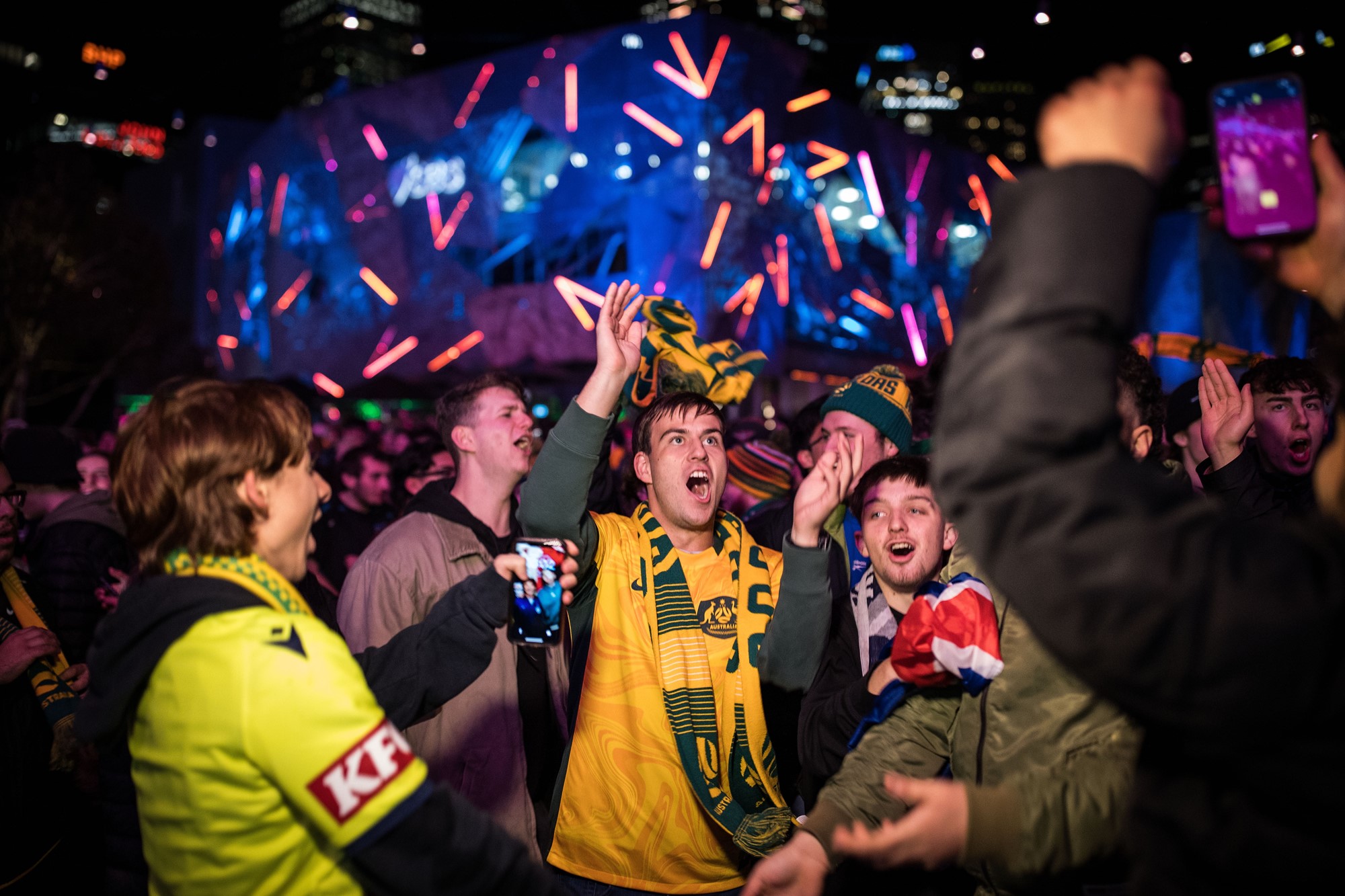 Young men scream in Federation Square.