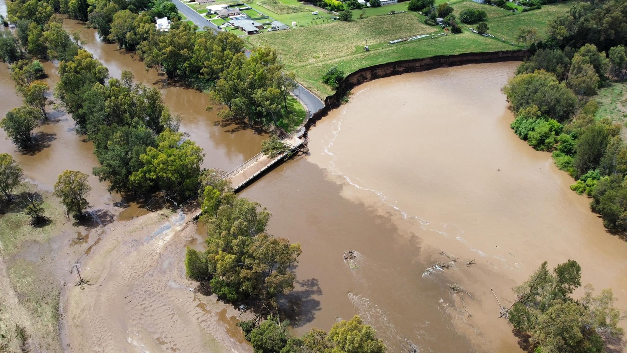 Photo shows an aerial view of a flooded road.
