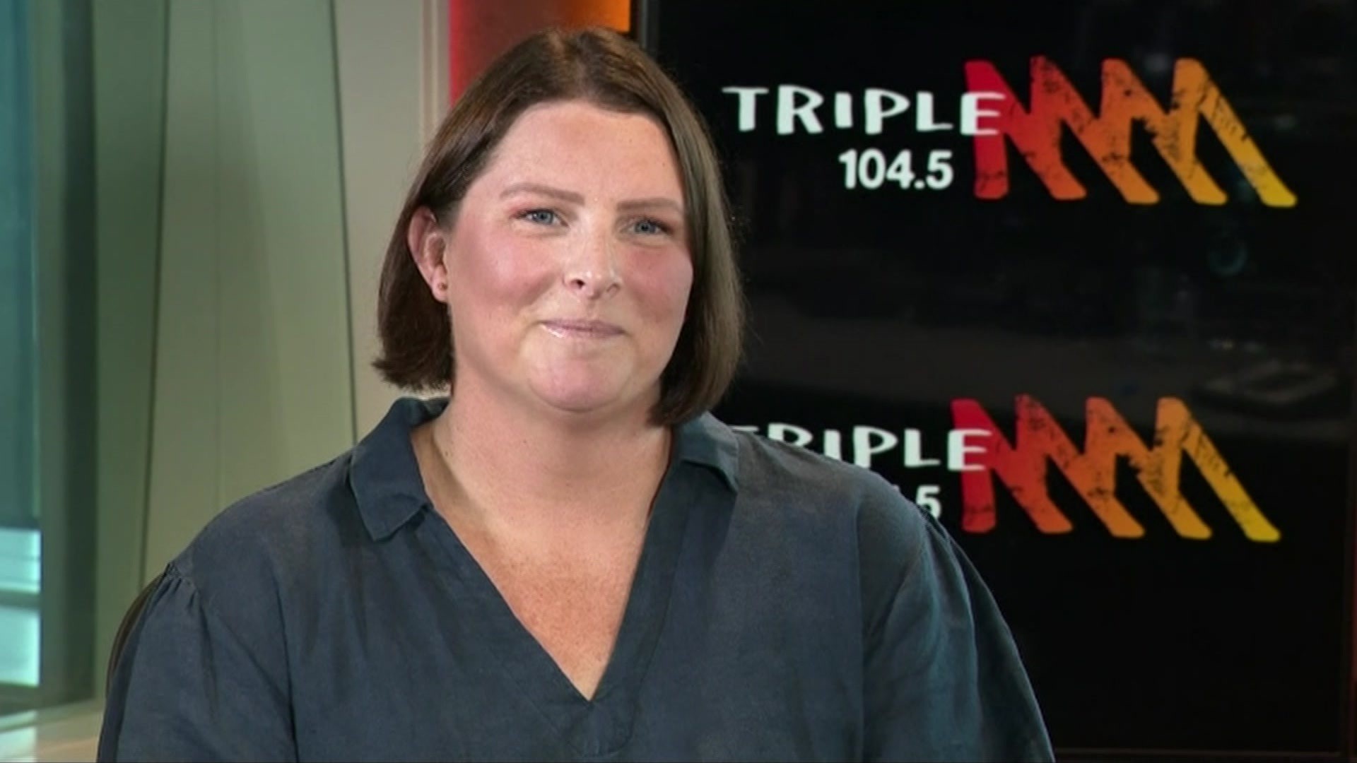 Leisel Jones in front of a Triple M sign.