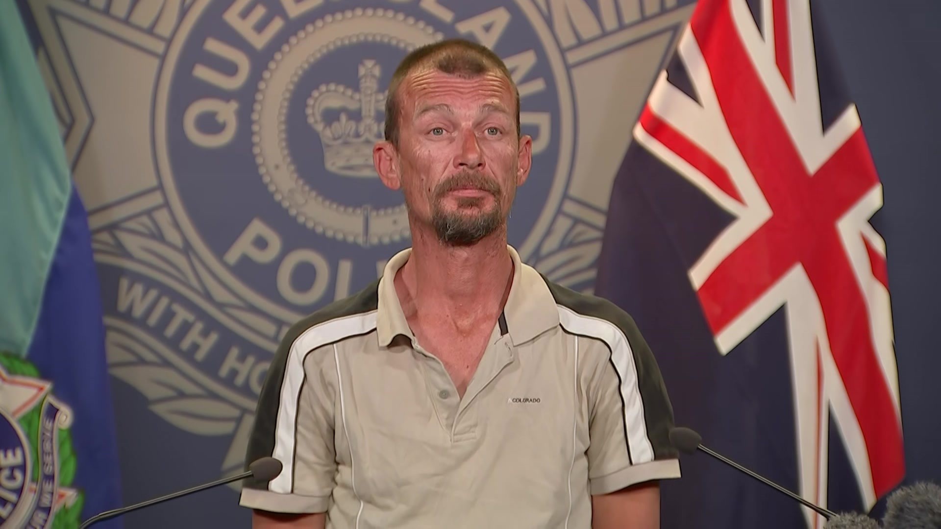 A man stands in front of a Qld police lecturn.