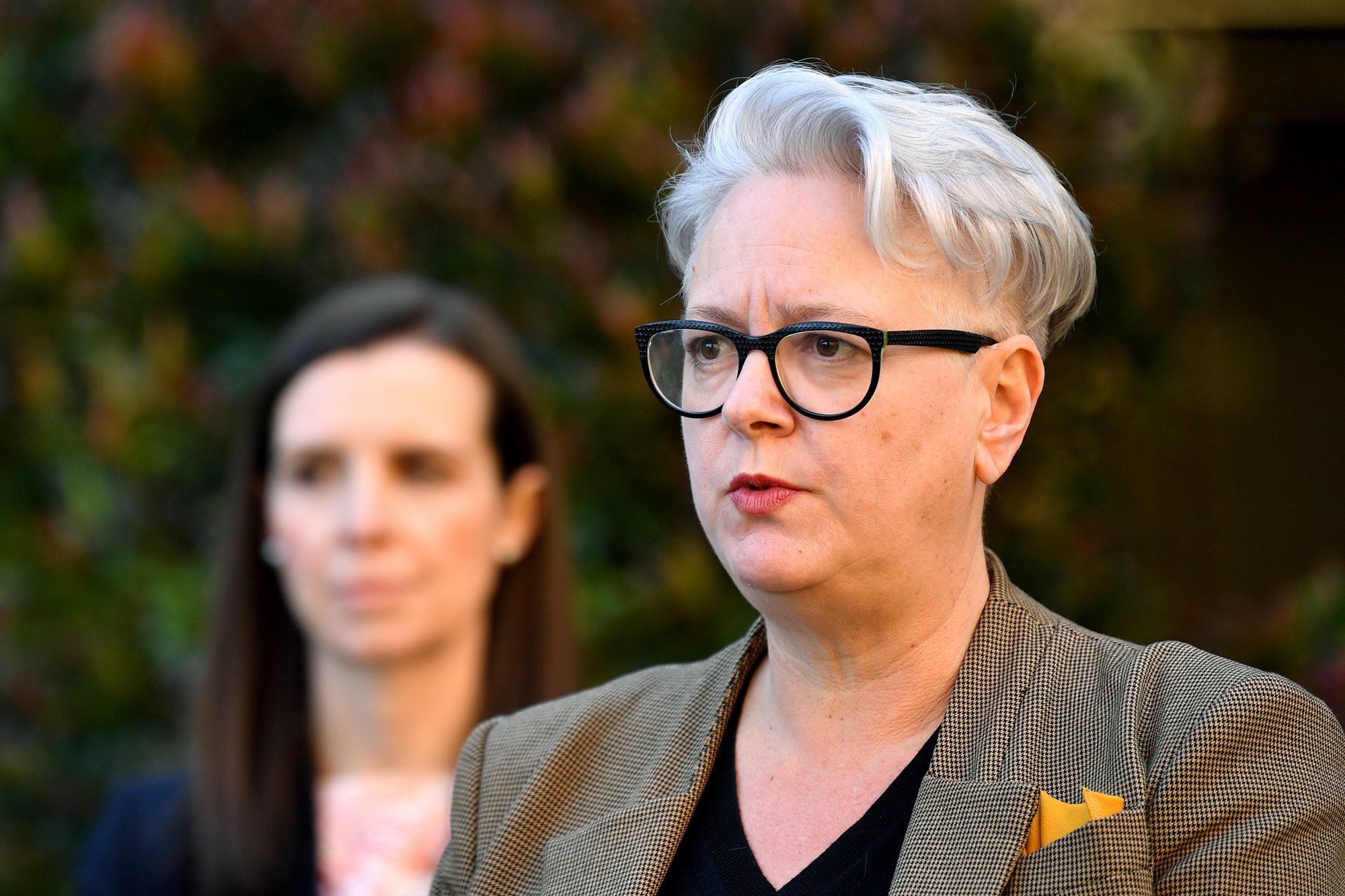 A woman with white hair and black glasses