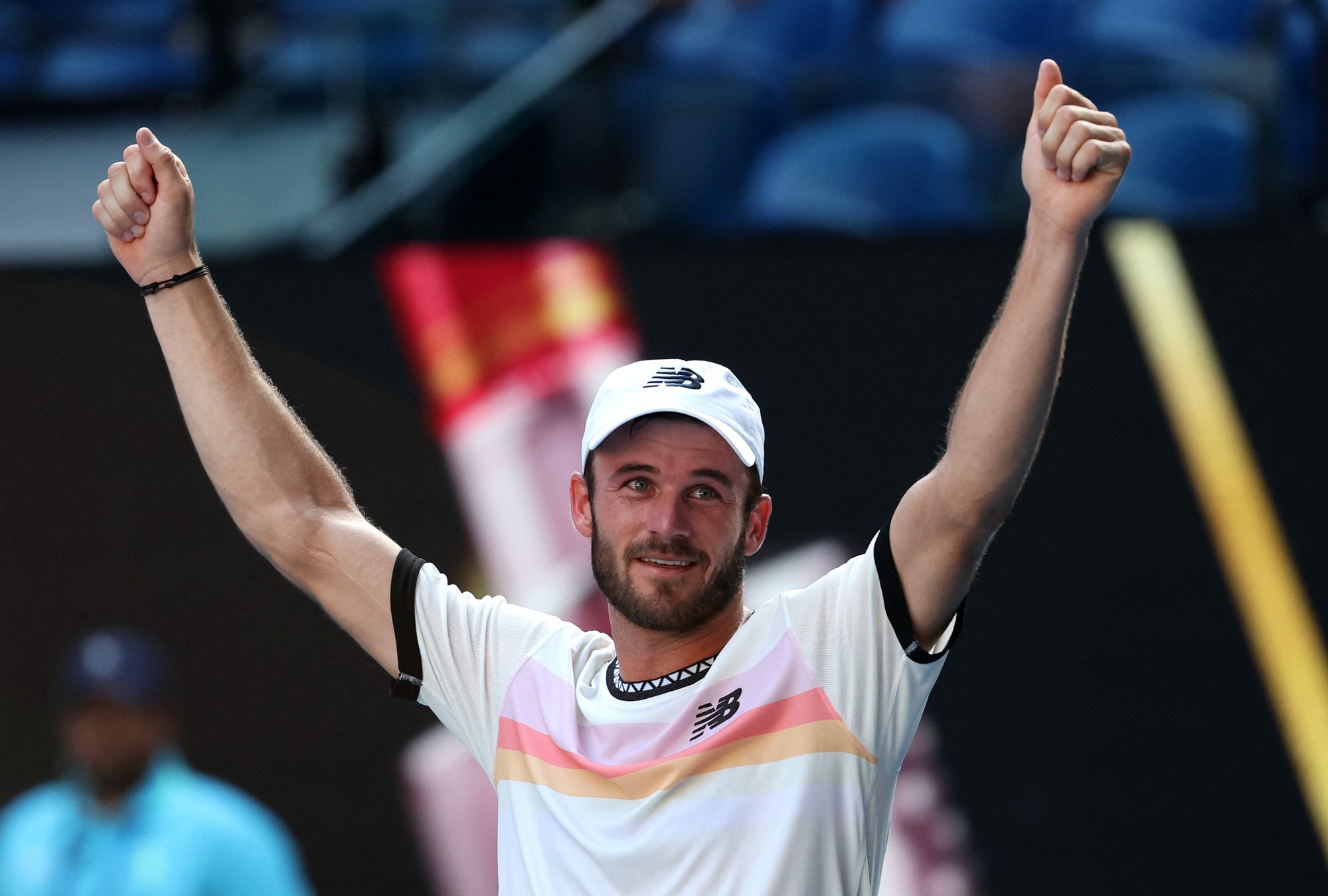 A tennis player raises his arms.