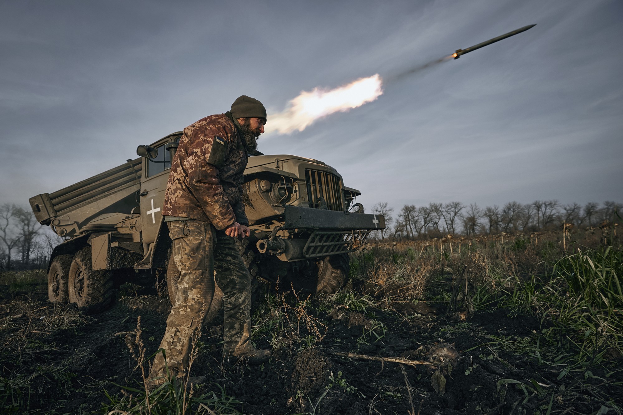A rocket launches near a Ukrainian soldier.