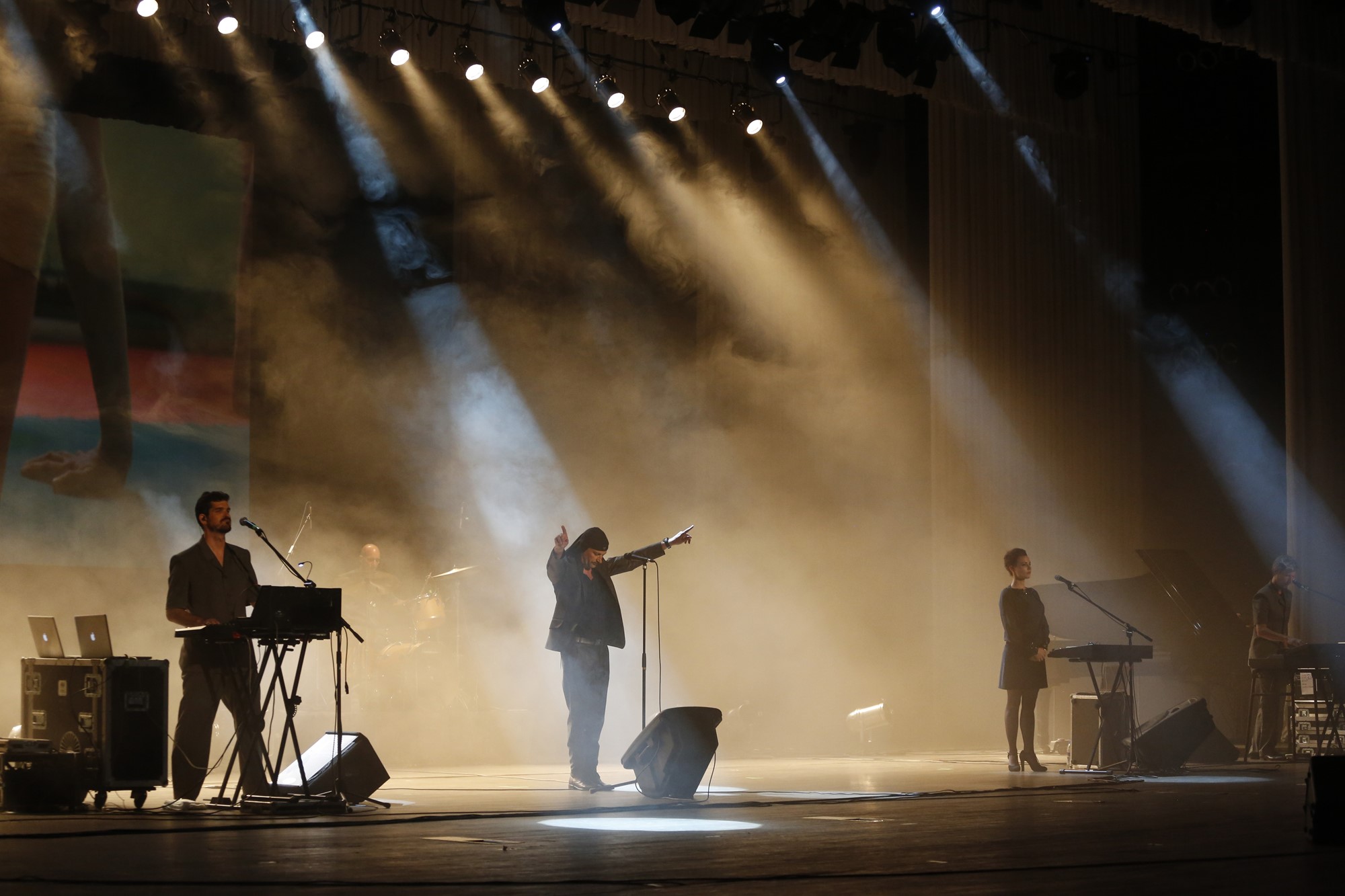 Three members of the band Lubraine stand on stage amid smoke and yellow light. 