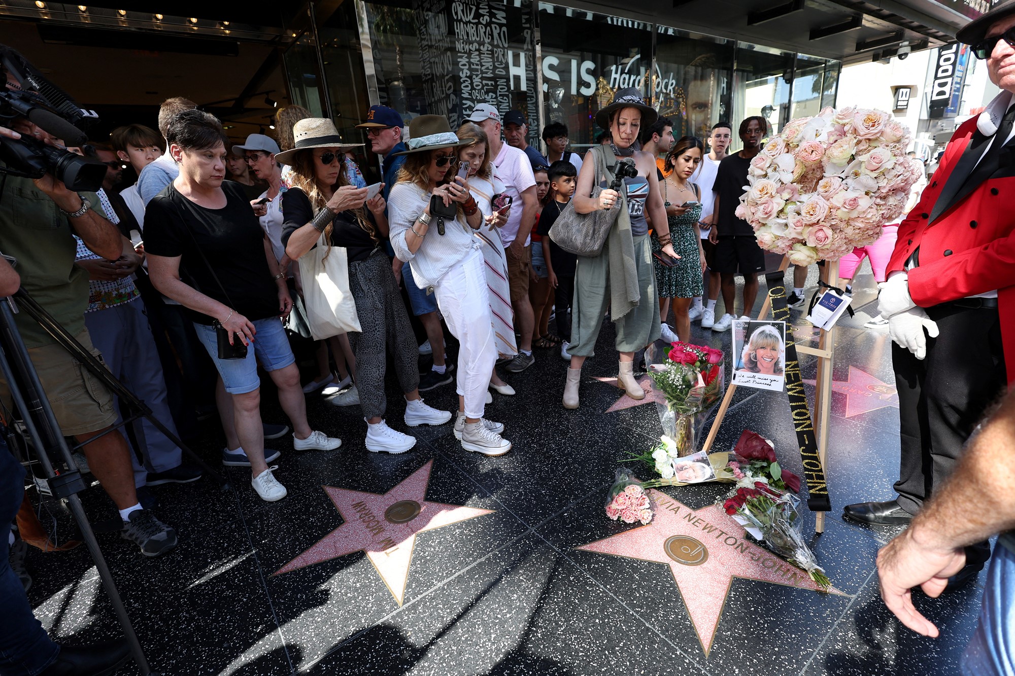 People surround Olivia Newton John's star on the Hollywood Walk of Fame.