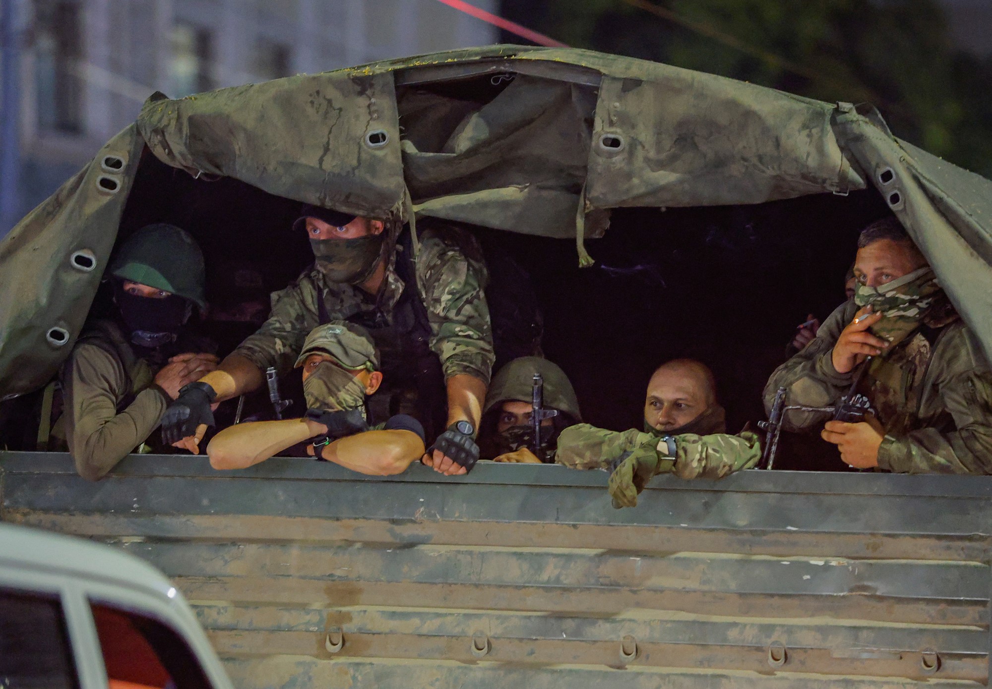 Six soldiers are pictured in the back of an army vehicle.