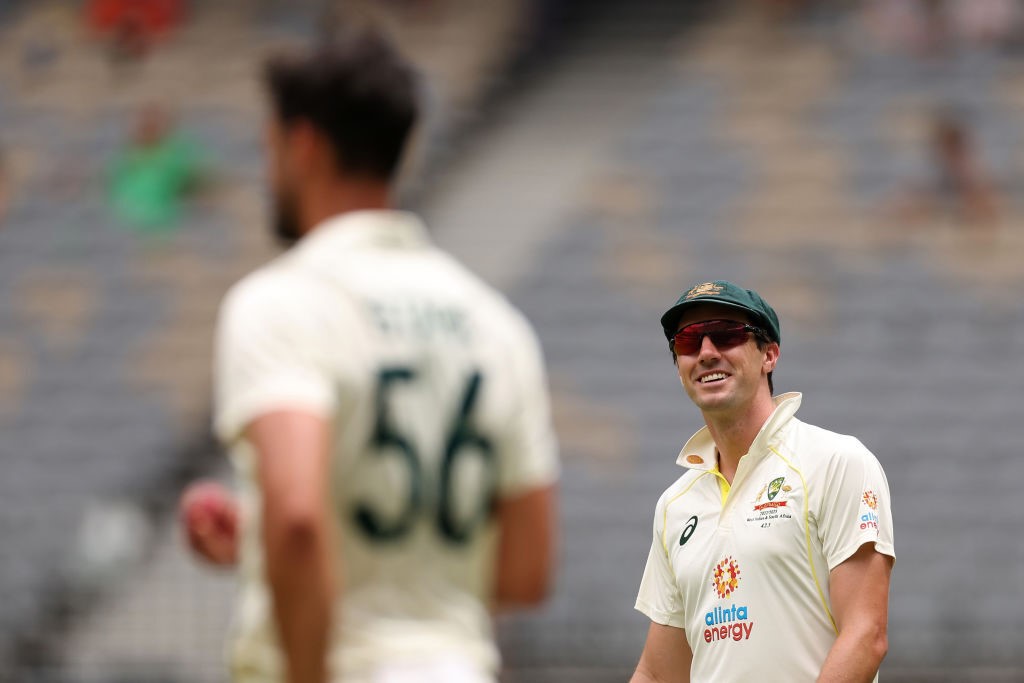 Pat Cummins smiles at fellow Australian bowler Mitchell Starc during a Test against West Indies.