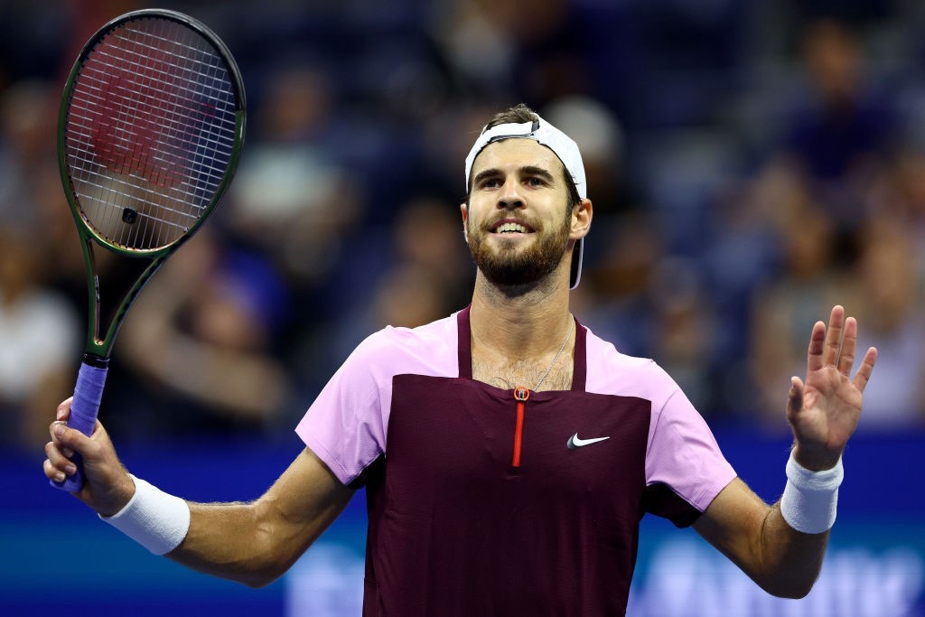 Karen Khachanov smiles as he holds up his hands at the US Open.
