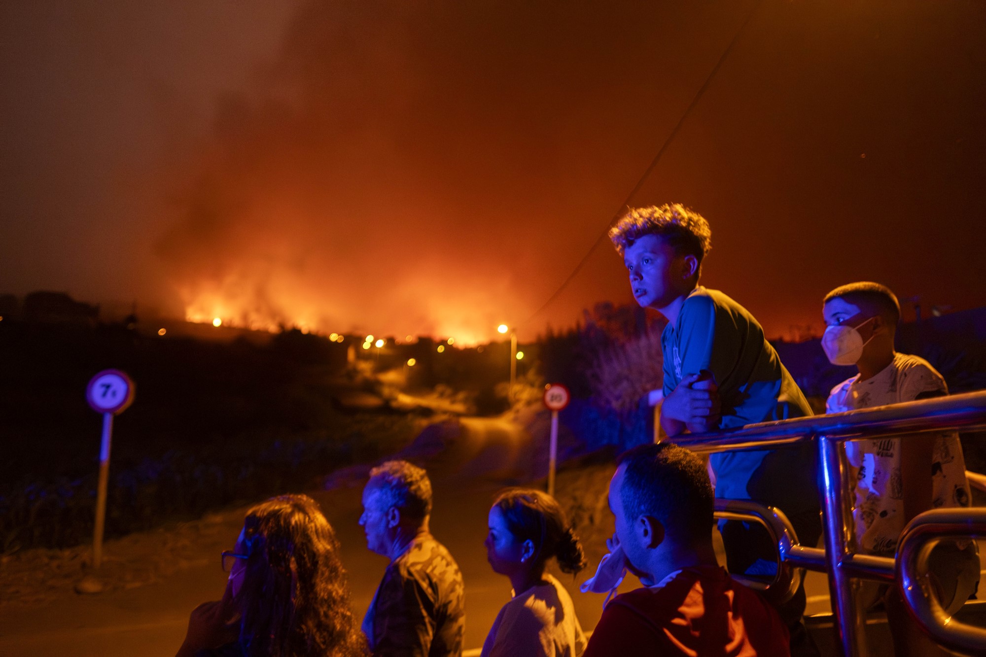 A group of people watch on as fire burns 