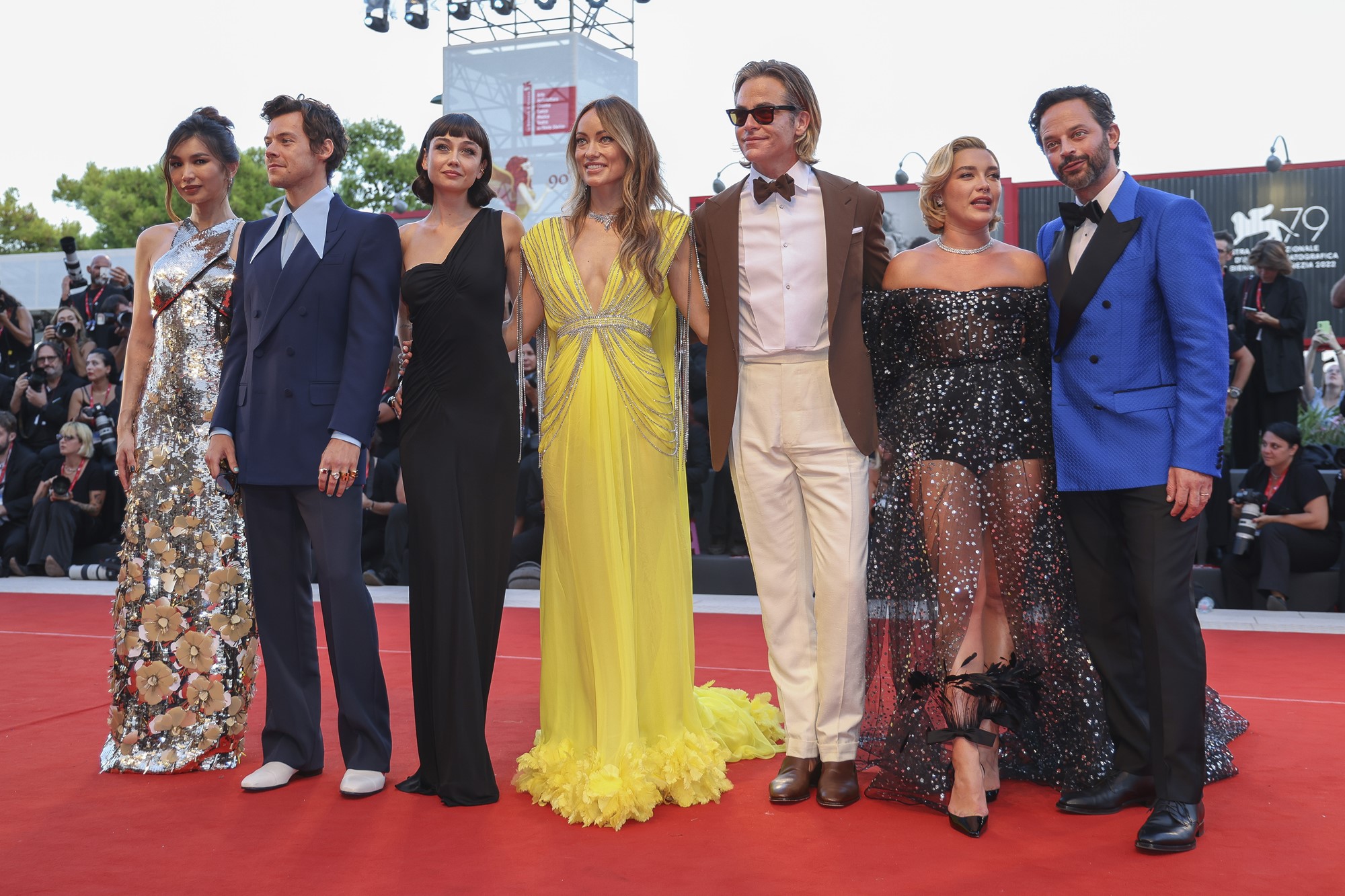 cast of don't worry darling poses on red carpet arm in arm