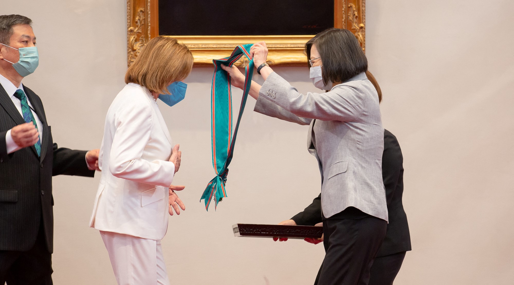 A woman presents another woman with a sash.
