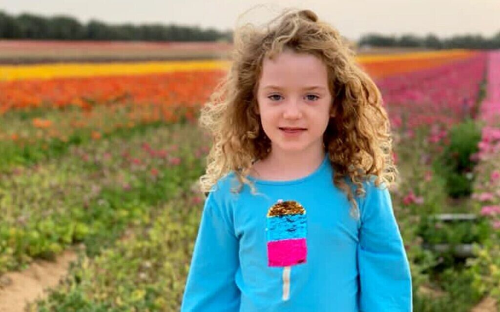 A little girl standing in a flower field