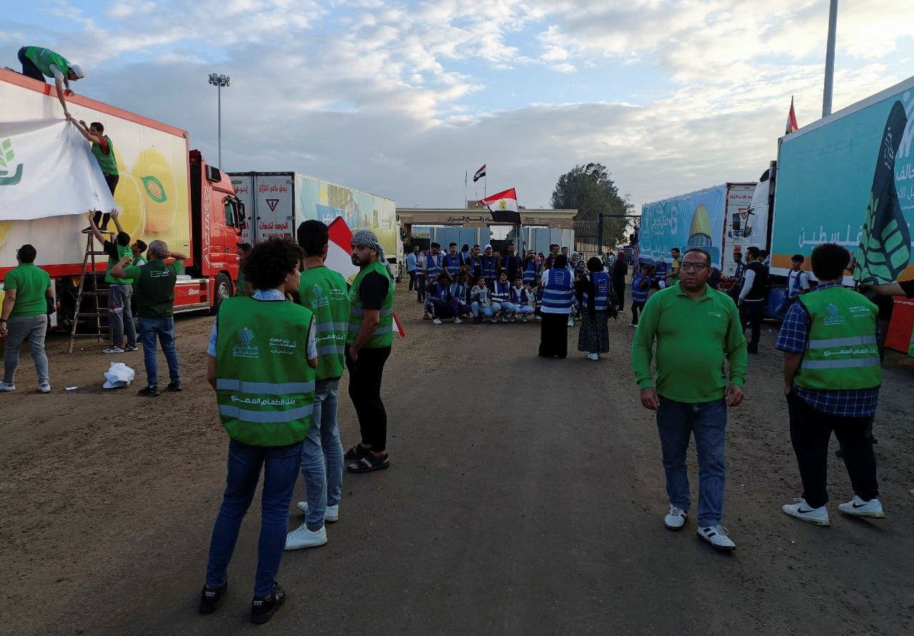 Egyptian volunteers gather next to a truck convoy carrying humanitarian aid from Egyptian NGOs for Palestinians