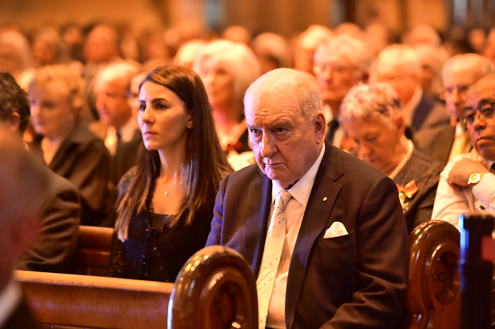 Alan Joyce sits in a crowded church.