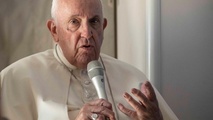 Close up on Pope Francis speaking into a microphone.