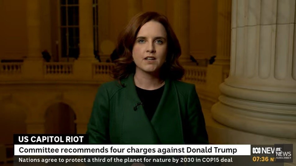 A woman with brown hair and a green blazer speaks from Washington.