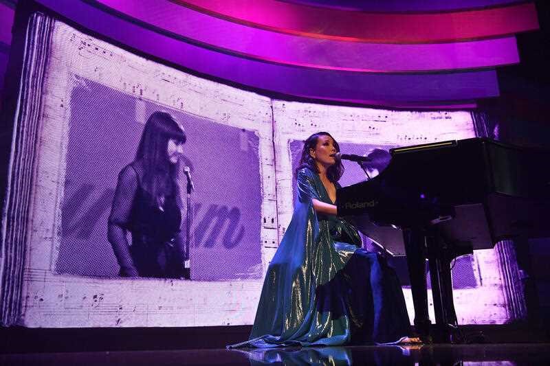 dami im sings in front of a big picture of judith durham