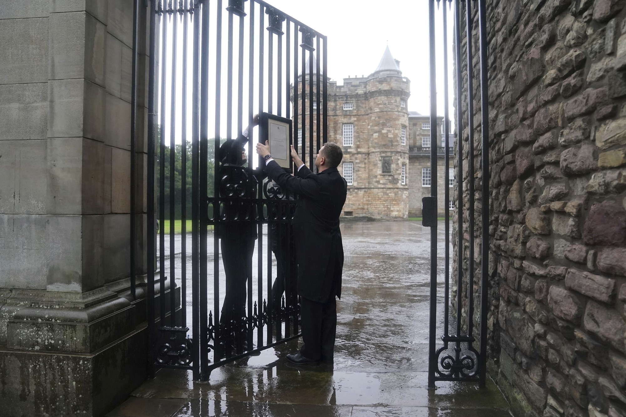 Les membres du personnel de la maison royale affichent un avis sur les portes du palais de Holyroodhouse