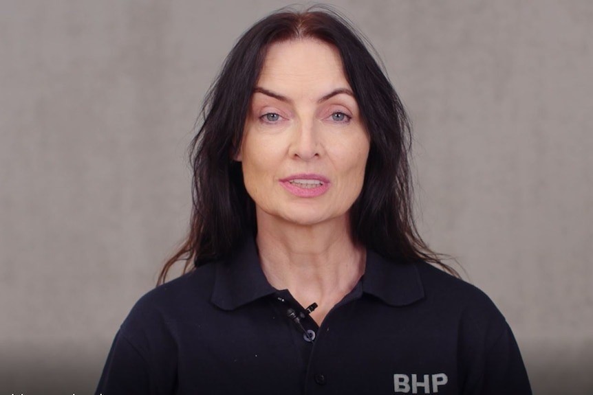 A middle aged woman with long dark hair wearing a black BHP polo shirt.