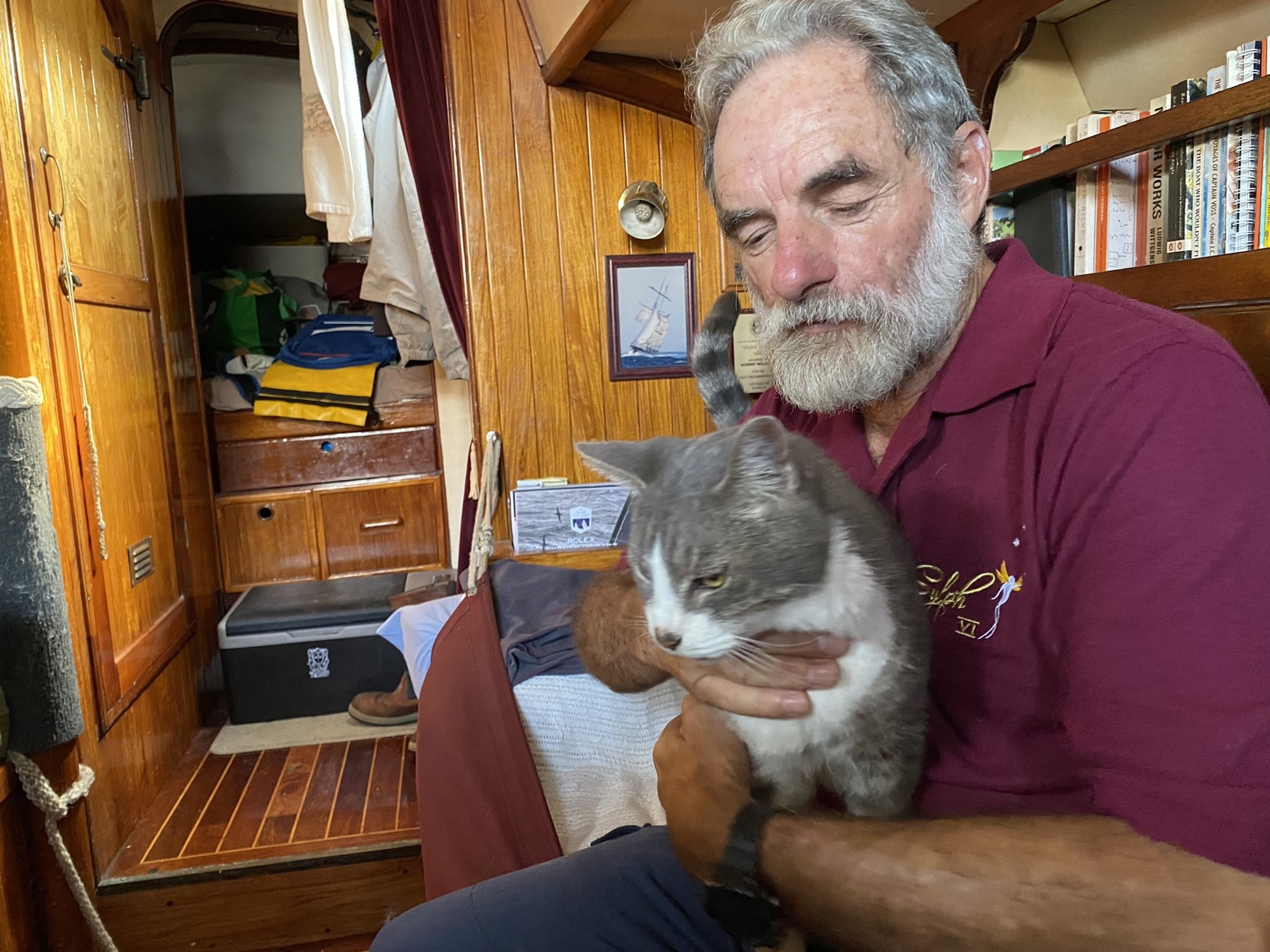 Skipper Bob Williams holds his cat Oli on board Sylph VI