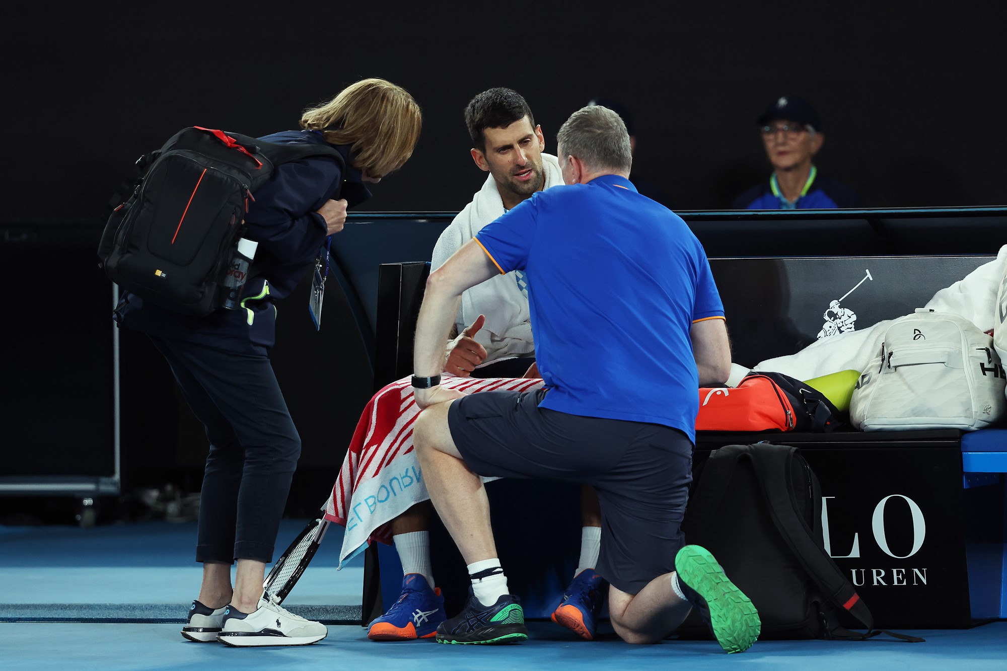 Two physios see to a tennis player.