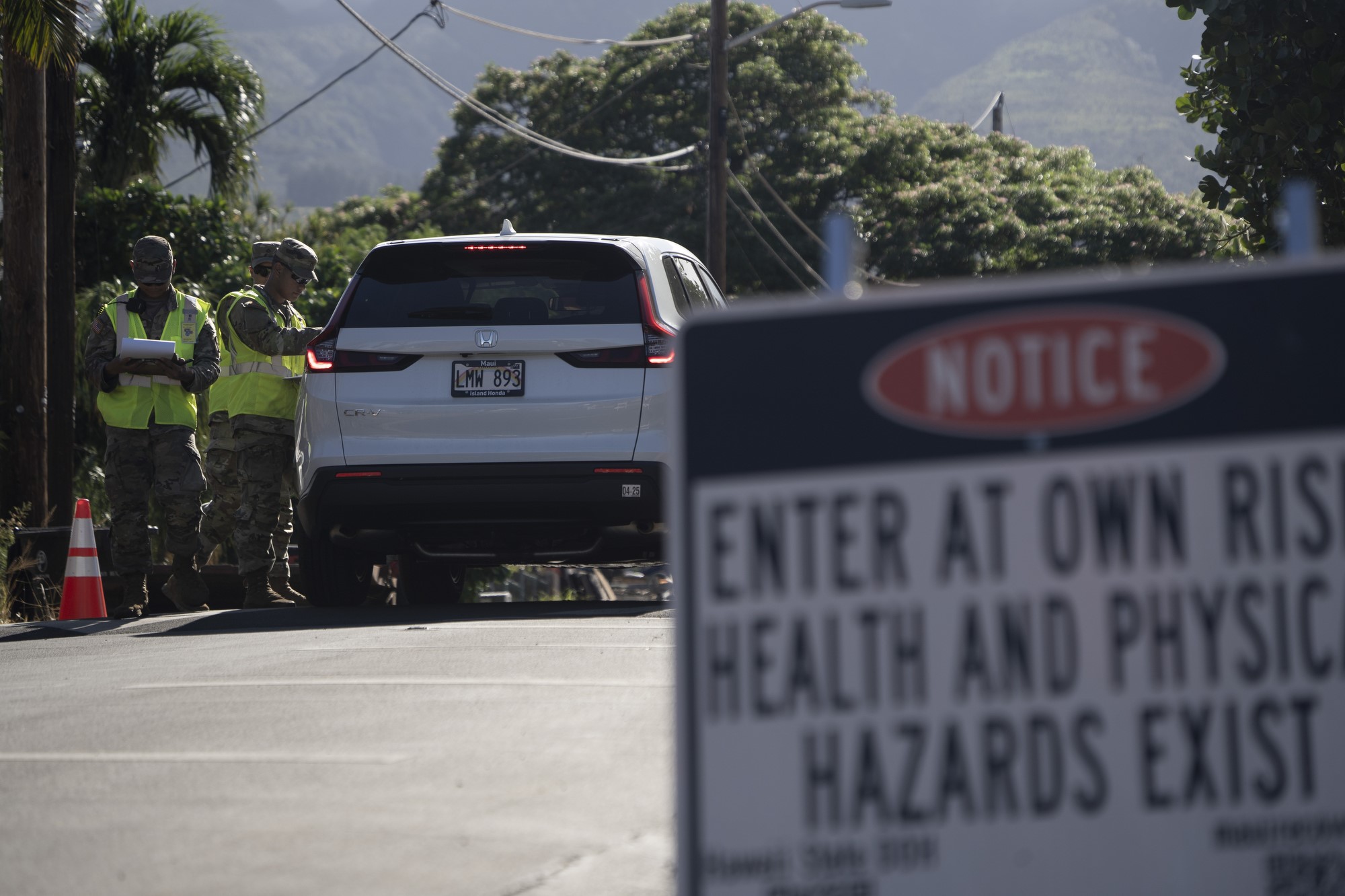 Two National Guards speak to a car driving into the disaster zone.