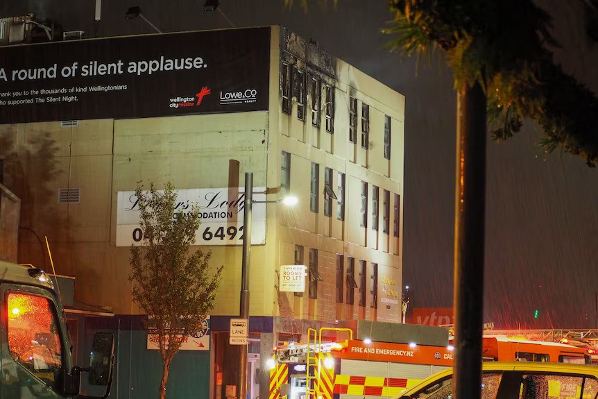 An exterior of a hostel building, with a firetruck out the front