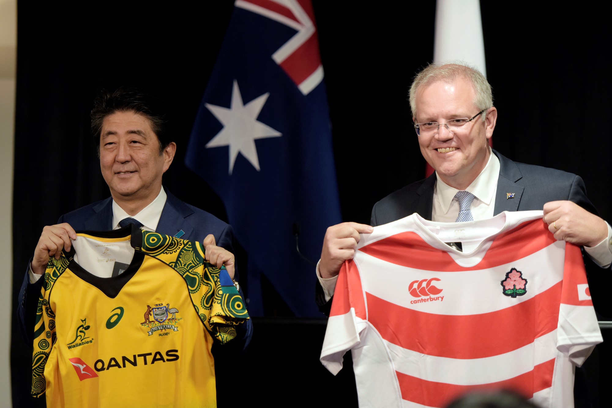 Japanese Prime Minister Shinzo Abe and Australian Prime Minister Scott Morrison hold up rugby jerseys after bilateral talks at Northern Territory Parliament House in Darwin