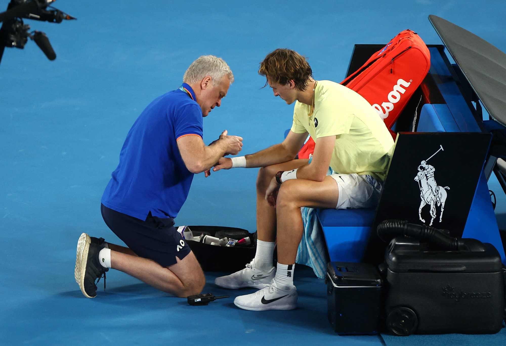 A physio attends to a tennis player.