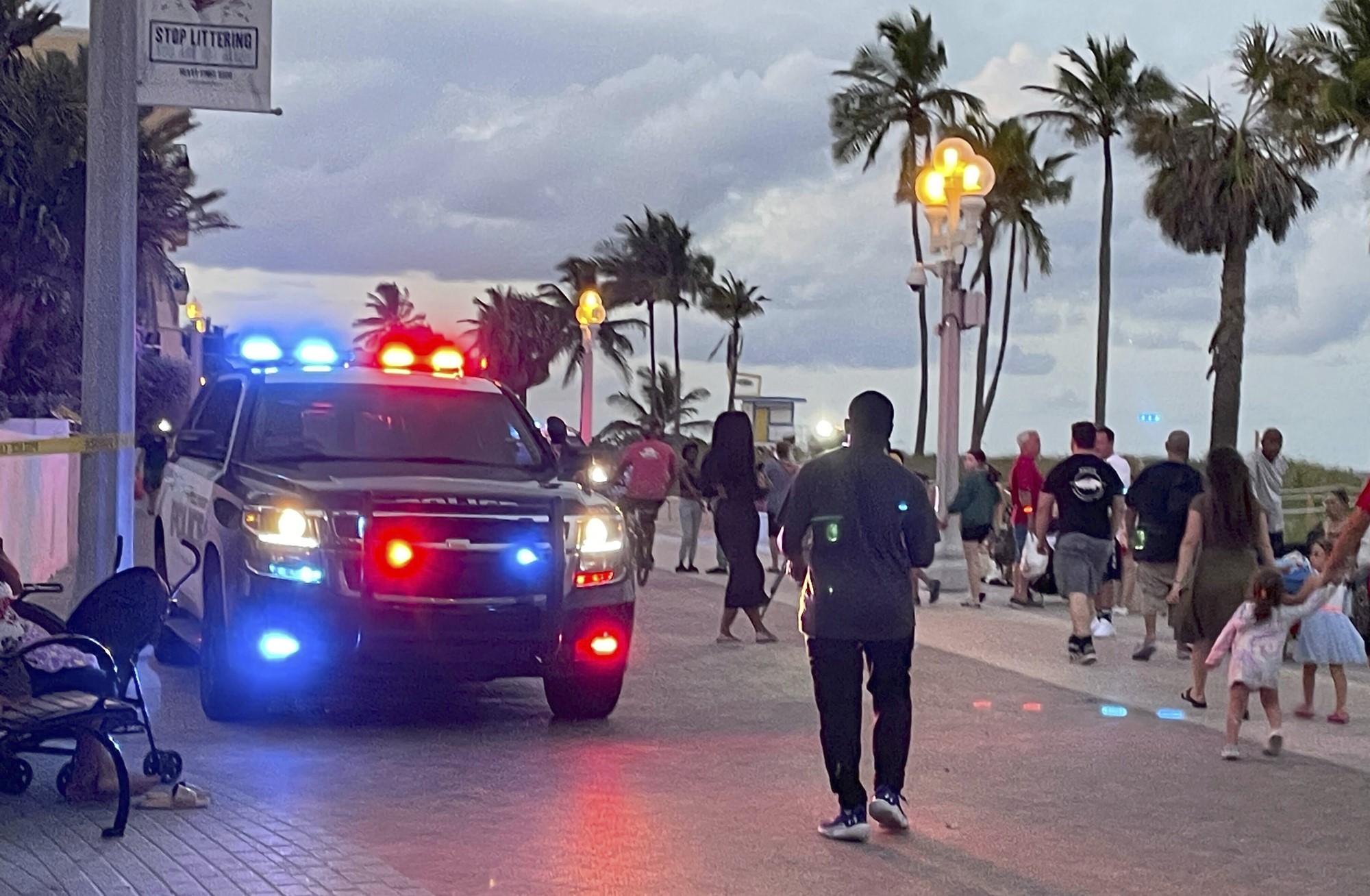 A police vehicle on a beach boardwalk, as people walk around it