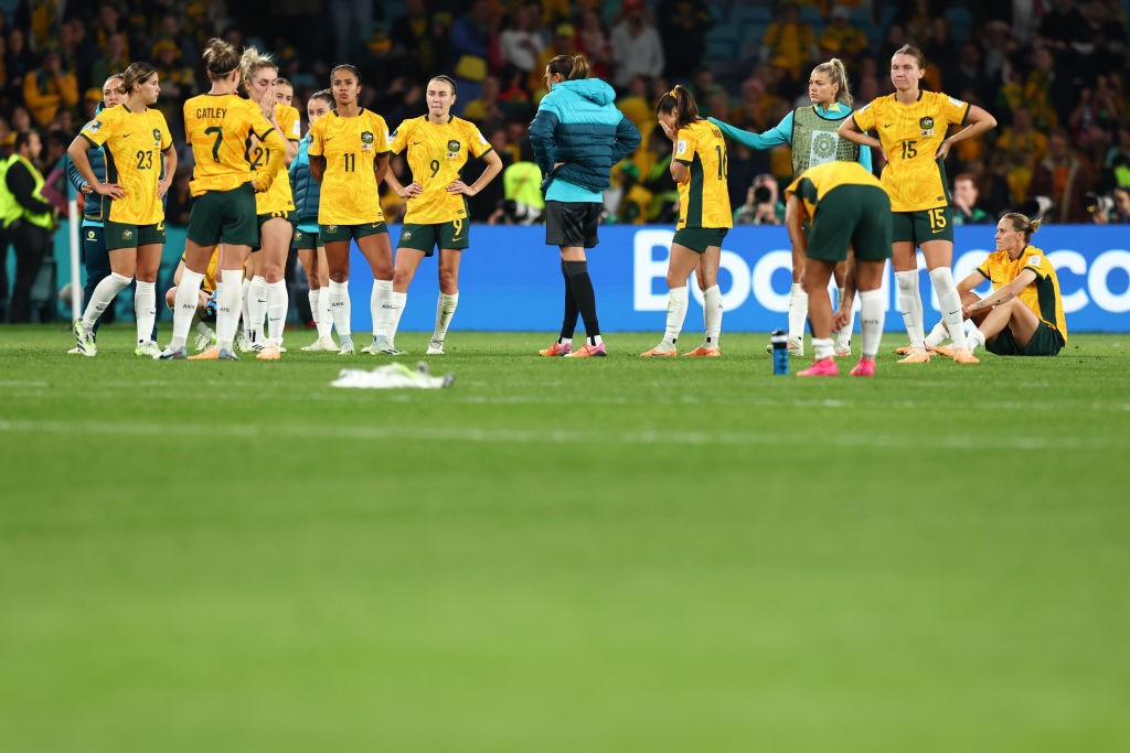 Australian Matildas players on the turf after losing the Women's World Cup semifinal.