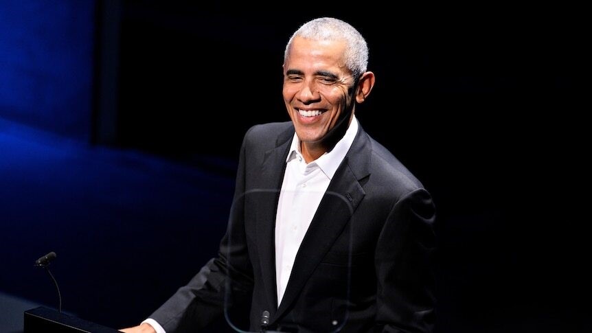 Obama smiles on stage at a previous event.