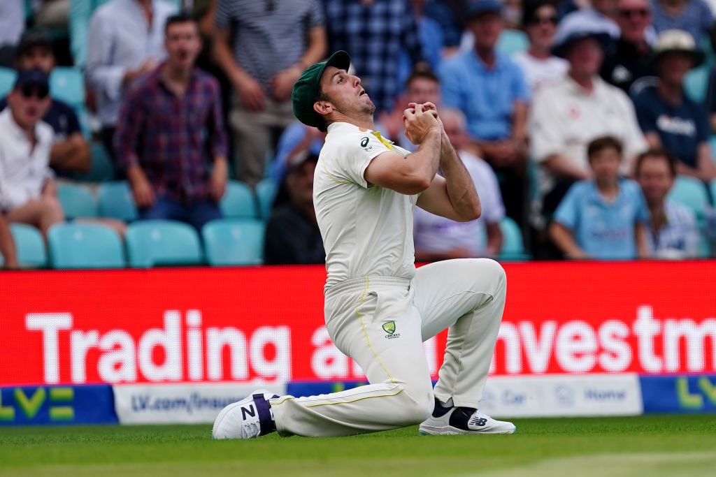 Australia fielder Mitch Marsh takes a catch while falling onto one knee.
