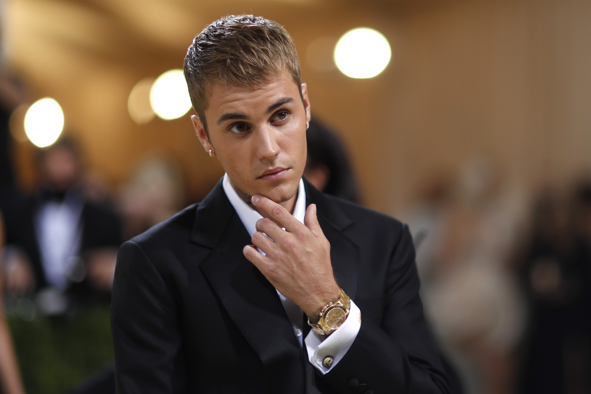 Justin poses at an event in a black suit.