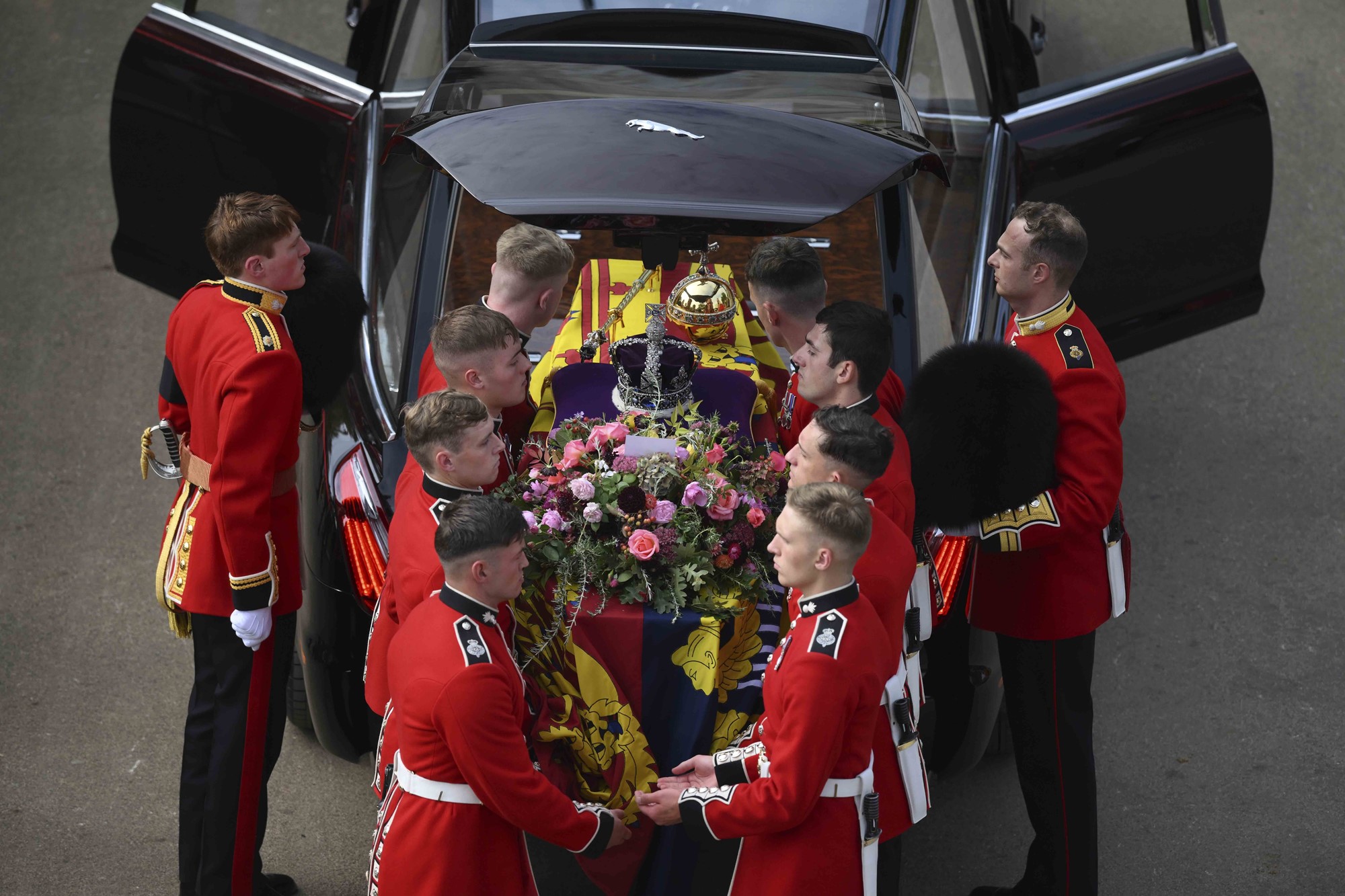 Pallbearers move the Queen's coffin into a car