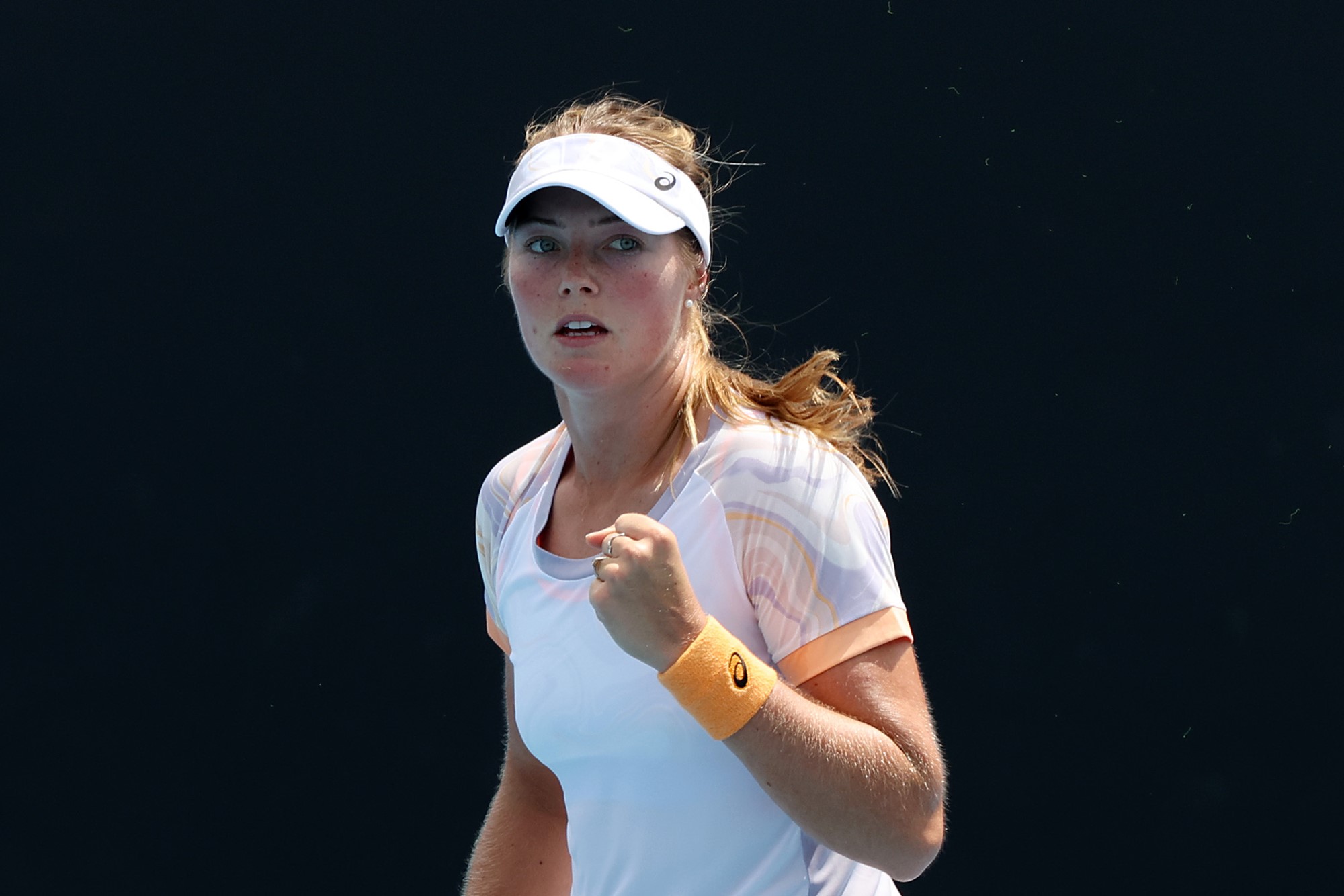 A female tennis player clenches her fist