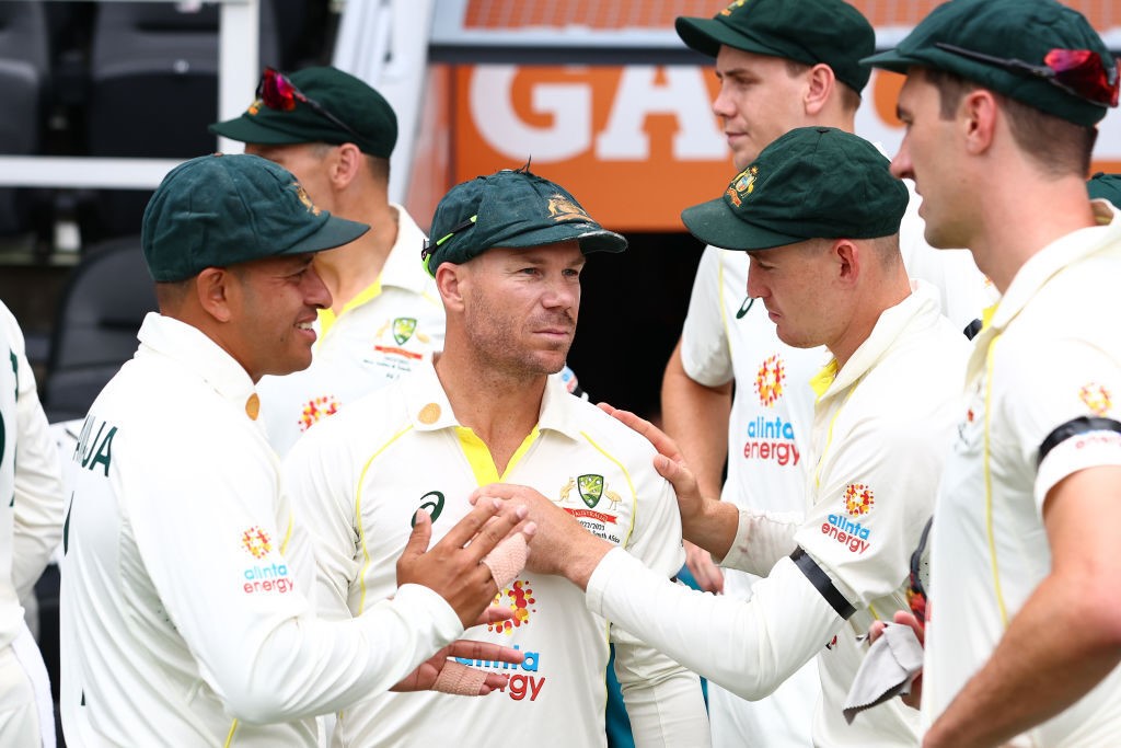 Australia teammates embrace David Warner on day one of the first Test against South Africa at the Gabba.