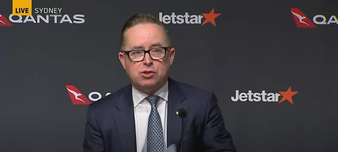 Alan Joyce in front of a Qantas and Jetstar backdrop. 