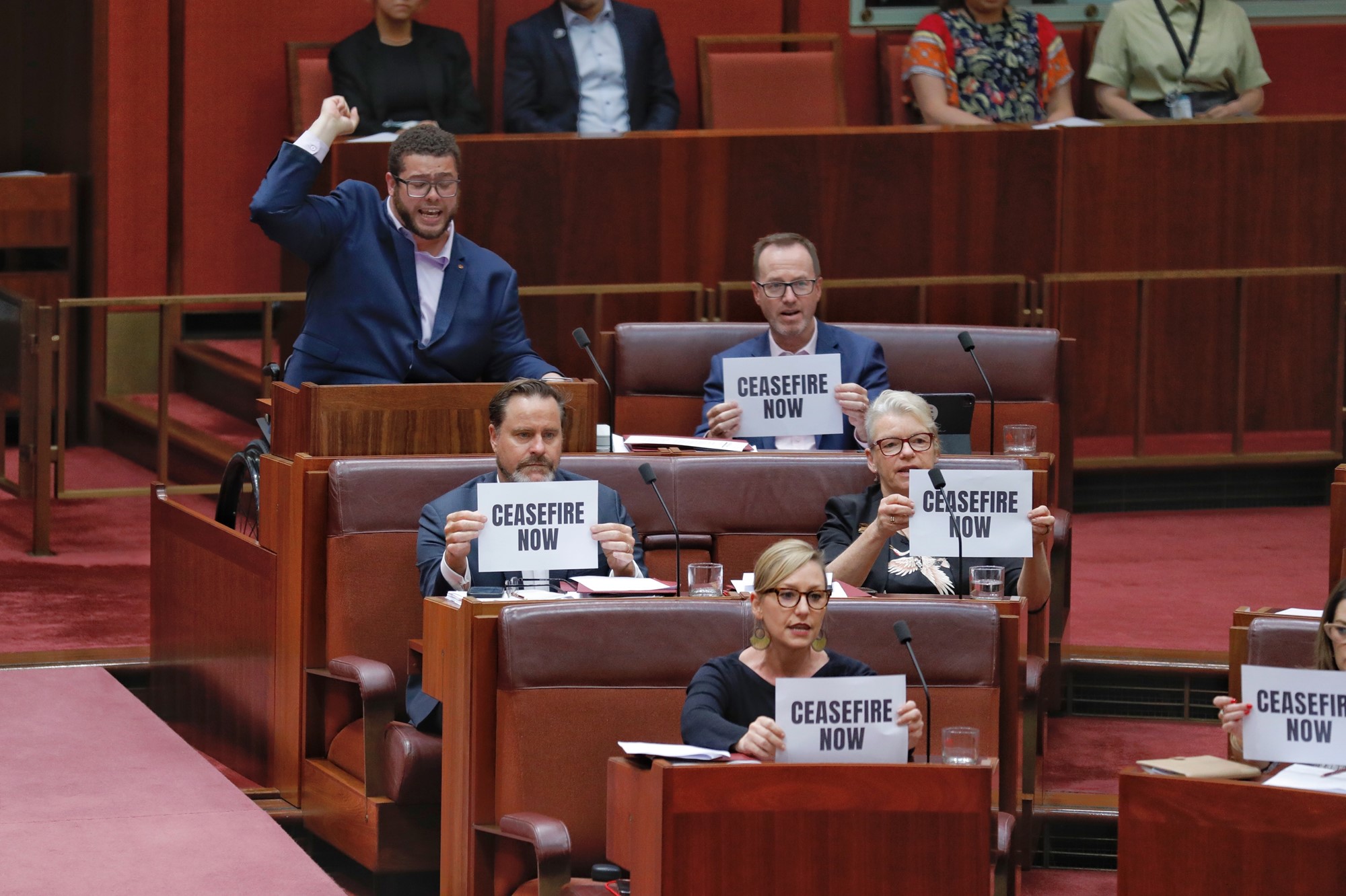 An image of Greens Senators holding up posters