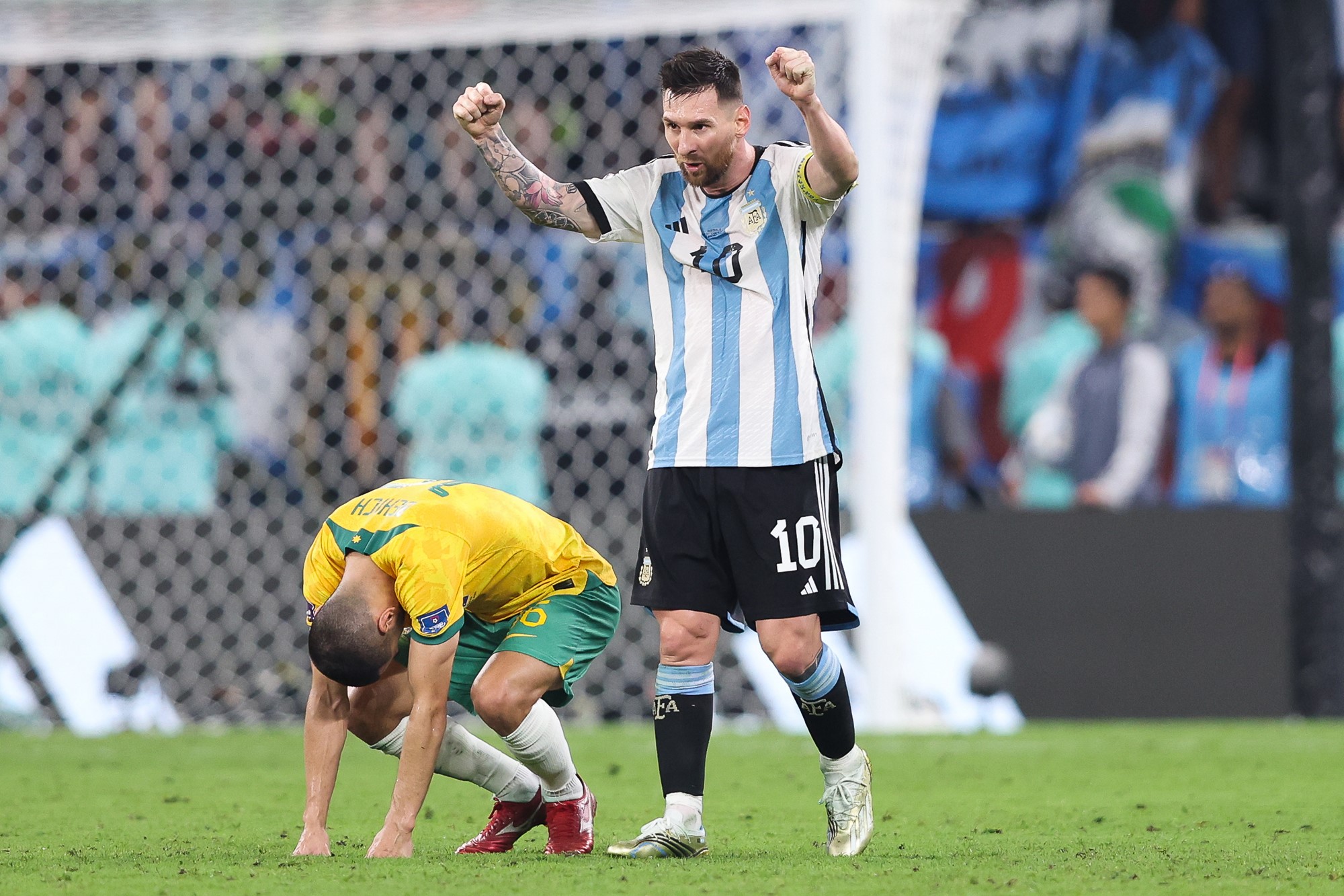 Lionel Messi celebrates next to a dejected Aziz Behich for Australia