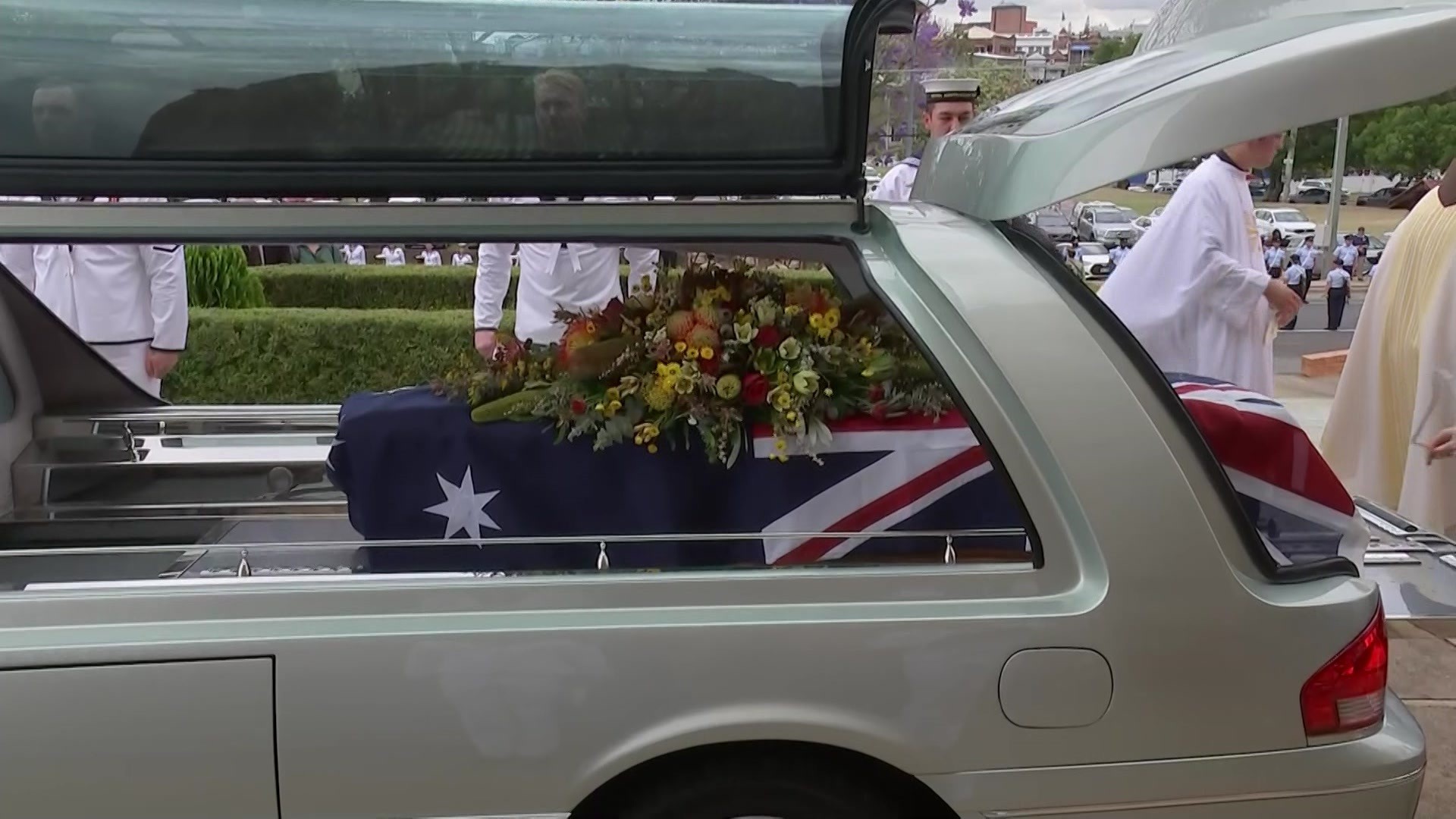 Bill Hayden's coffin leaves the church in a herse with flowers.