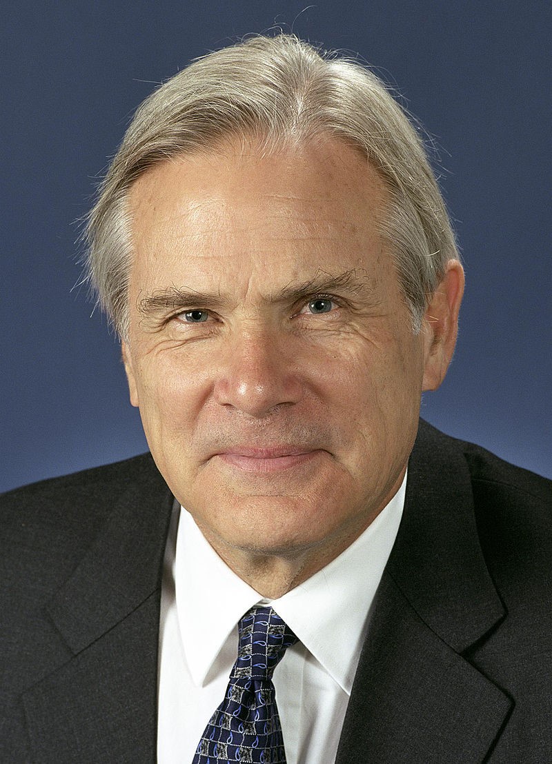  A man with grey hair, wearing a suit.