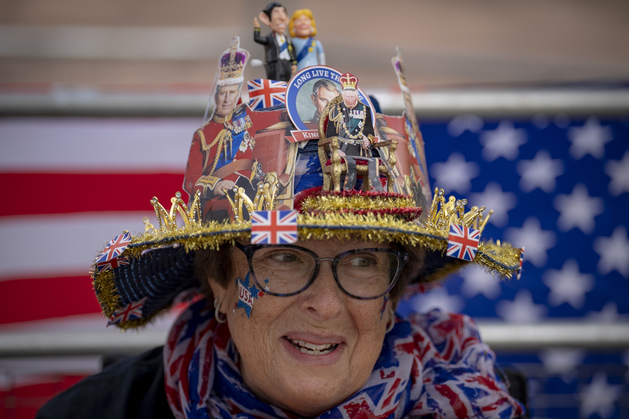 A woman wearing a hat decorated with royal imagery and images of King Charles III