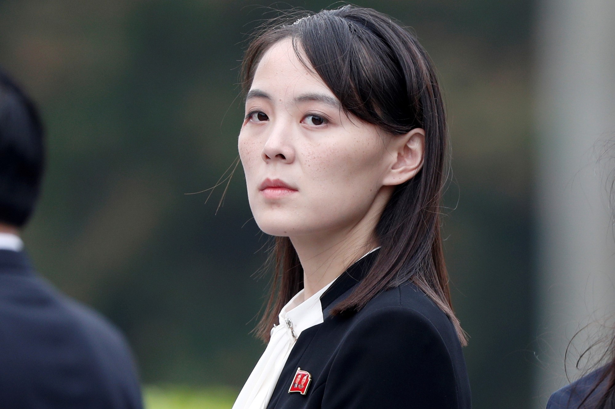 Kim Yo Jong looks into the camera wearing a black suit