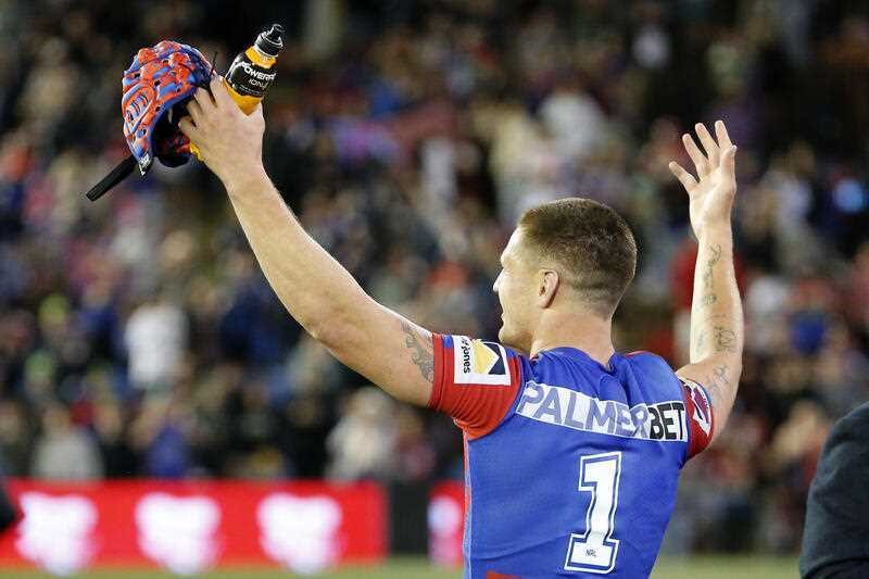 Kalyn Ponga raises his arms in front of Newcastle Knights fans.