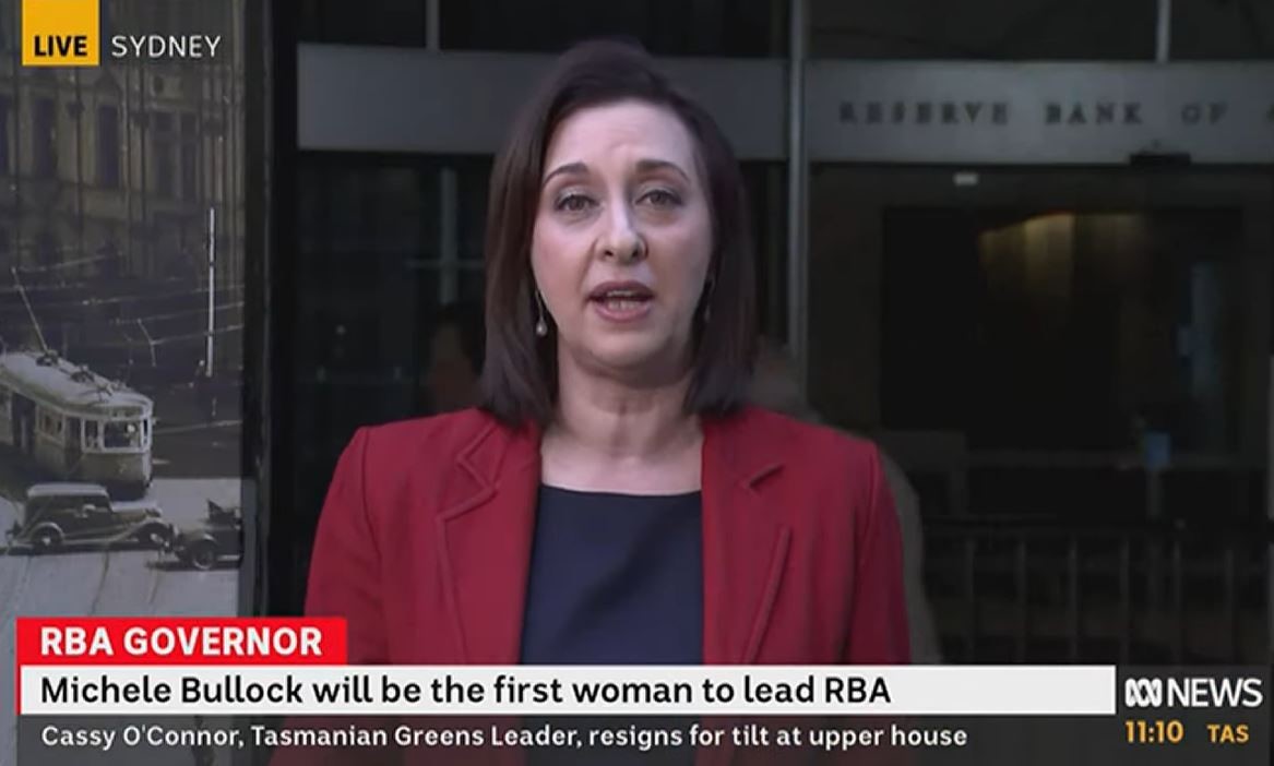 A woman with a brown bob and red blazer stands outside the Reserve Bank of Australia building in Sydney.