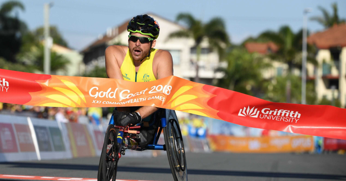 Kurt Fearnley crosses race tape at the end of a marathon.