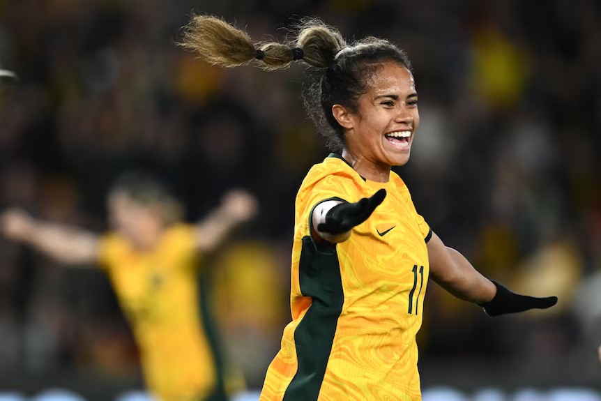 Mary Fowler runs across the soccer pitch in a Matildas jersey.