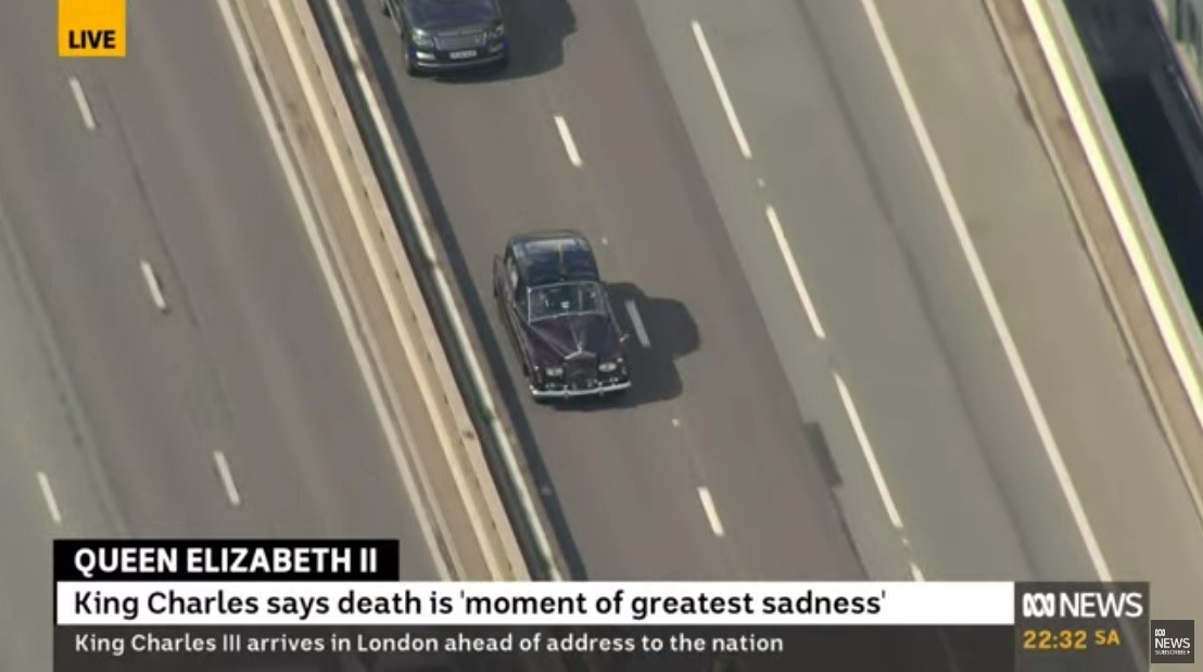 A motorcade is seen from above from a news camera.