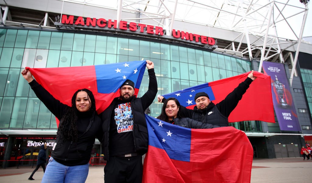 Fans hold up Samoan flags outside Old Trafford before the Rugby League World Cup final.